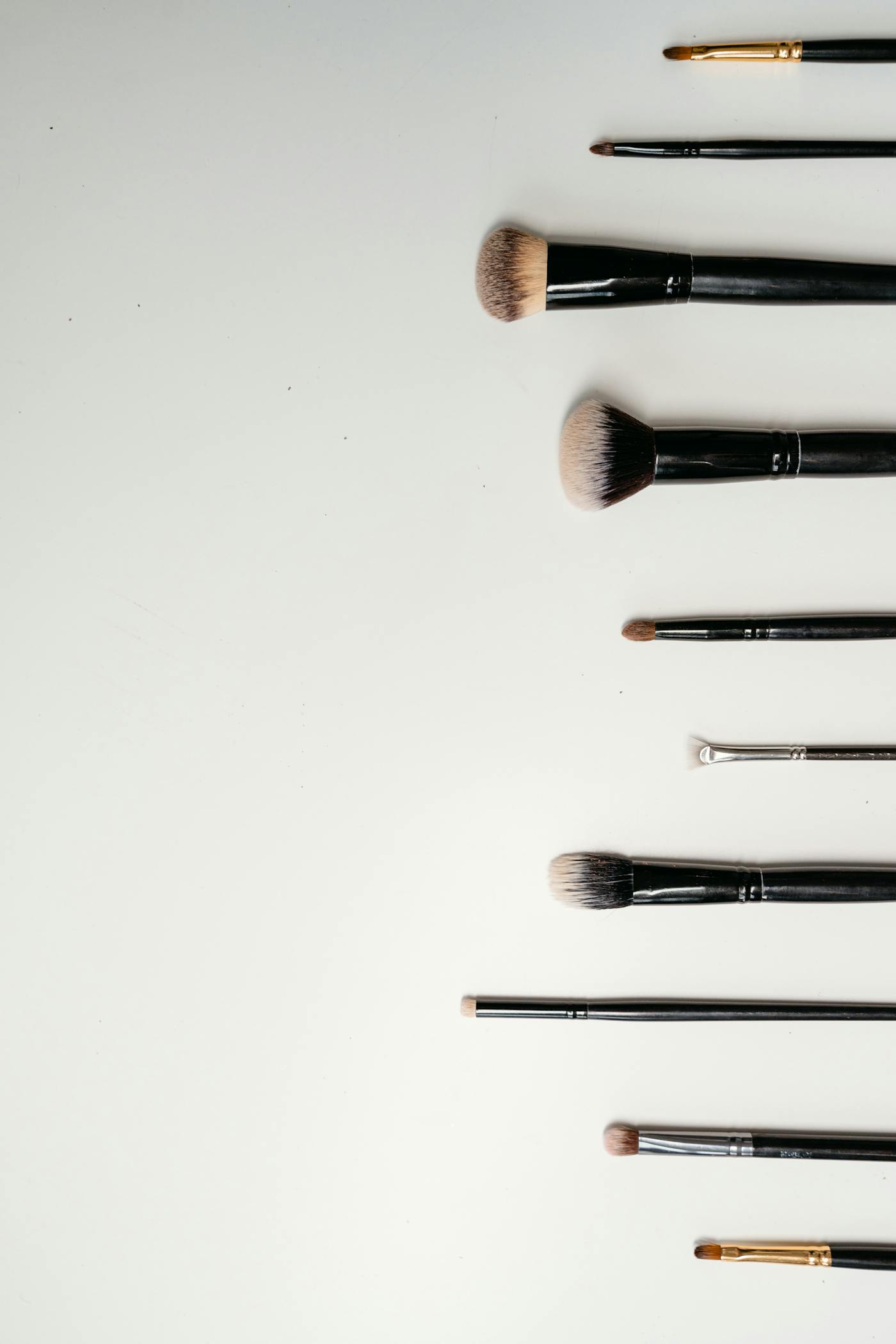 Brochas y accesorios de maquillaje sobre fondo claro